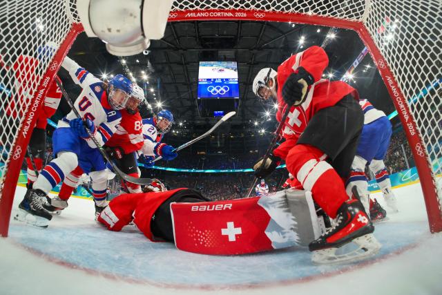 Switzerland's #20 Andrea Braendli (C) makes a save during the women's preliminary round Group A Ice Hockey match between Switzerland and USA at the Milano Santagiulia Ice Hockey Arena at the Milano Cortina 2026 Winter Olympic Games in Milan, on February 9, 2026. (Photo by Bruce BENNETT / POOL / AFP)