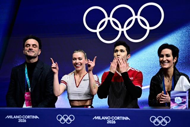 Canada's Marjorie Lajoie (2nd L) and Canada's Zachary Lagha (2nd R) react in the kiss and cry area after competing in the figure skating team event ice dance-rhythm dance during the Milano Cortina 2026 Winter Olympic Games at Milano Ice Skating Arena in Milan on February 9, 2026. (Photo by JULIEN DE ROSA / AFP)