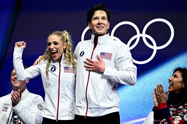 USA's Emilea Zingas (2nd L) and USA's Vadym Kolesnik (2nd R) react in the kiss and cry area after competing in the figure skating team event ice dance-rhythm dance during the Milano Cortina 2026 Winter Olympic Games at Milano Ice Skating Arena in Milan on February 9, 2026. (Photo by JULIEN DE ROSA / AFP)