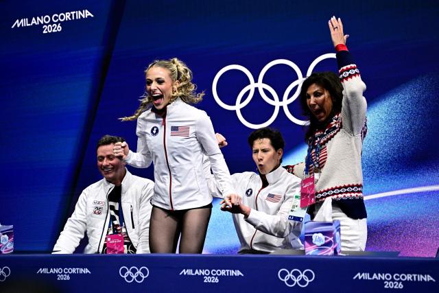 USA's Emilea Zingas (2nd L) and USA's Vadym Kolesnik (2nd R) react in the kiss and cry area after competing in the figure skating team event ice dance-rhythm dance during the Milano Cortina 2026 Winter Olympic Games at Milano Ice Skating Arena in Milan on February 9, 2026. (Photo by JULIEN DE ROSA / AFP)