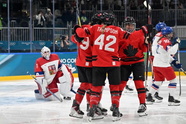 Czech Republic's #01 Michaela Hesova (L) looks on as Canada's players celebrate thei 5-0 goal scored by Canada's #88 Julia Gosling during the women's preliminary round Group A Ice Hockey match between Canada and Czech Republic at the Milano Rho Ice Hockey Arena at the Milano Cortina 2026 Winter Olympic Games in Milan, on February 9, 2026. (Photo by Alexander NEMENOV / AFP)