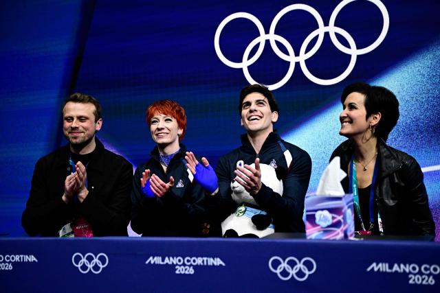 France's Evgeniia Lopareva (2nd L) and France's Geoffrey Brissaud (2nd R) react in the kiss and cry area after competing in the figure skating team event ice dance-rhythm dance during the Milano Cortina 2026 Winter Olympic Games at Milano Ice Skating Arena in Milan on February 9, 2026. (Photo by JULIEN DE ROSA / AFP)
