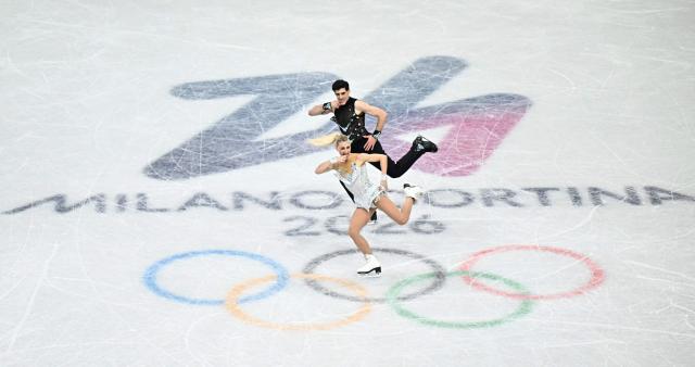 Canada's Piper Gilles and Canada's Paul Poirier compete in the figure skating team event ice dance-rhythm dance during the Milano Cortina 2026 Winter Olympic Games at Milano Ice Skating Arena in Milan on February 9, 2026. (Photo by Gabriel BOUYS / AFP)