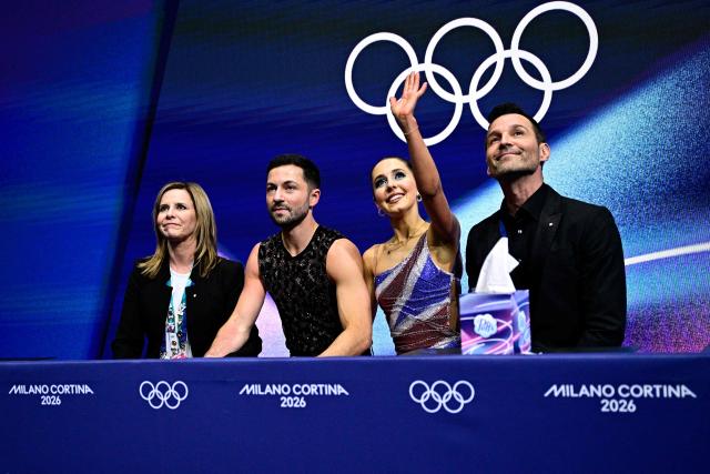 Britain's Lilah Fear (2nd R) and Britain's Lewis Gibson (2nd L) react in the kiss and cry area after competing in the figure skating team event ice dance-rhythm dance during the Milano Cortina 2026 Winter Olympic Games at Milano Ice Skating Arena in Milan on February 9, 2026. (Photo by JULIEN DE ROSA / AFP)