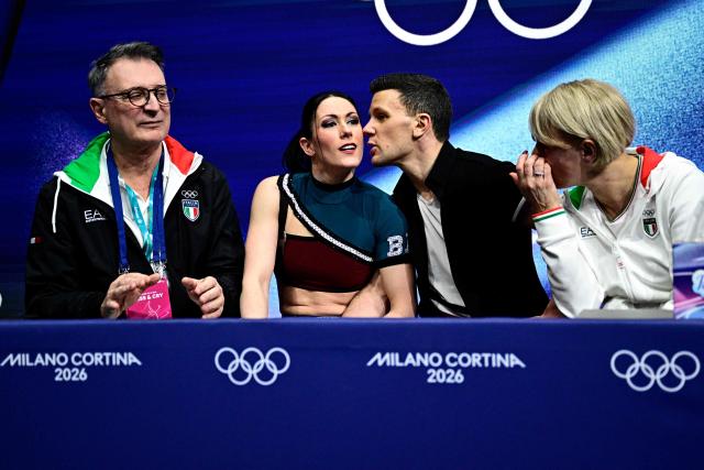 Italy's Charlene Guignard (2nd L) and Italy's Marco Fabbri (2nd R) react in the kiss and cry area after competing in the figure skating team event ice dance-rhythm dance during the Milano Cortina 2026 Winter Olympic Games at Milano Ice Skating Arena in Milan on February 9, 2026. (Photo by JULIEN DE ROSA / AFP)