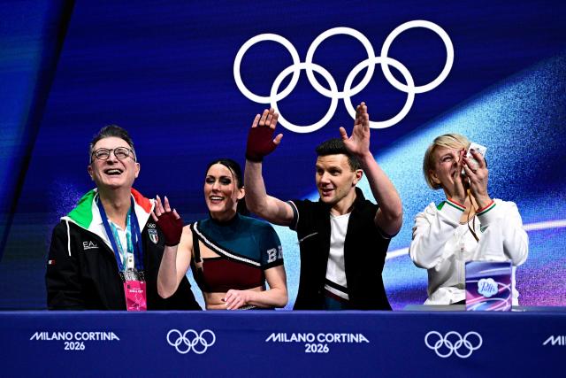 Italy's Charlene Guignard (2nd L) and Italy's Marco Fabbri (2nd R) react in the kiss and cry area after competing in the figure skating team event ice dance-rhythm dance during the Milano Cortina 2026 Winter Olympic Games at Milano Ice Skating Arena in Milan on February 9, 2026. (Photo by JULIEN DE ROSA / AFP)