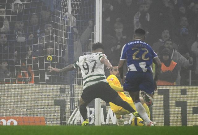 Sporting Lisbon's Colombian forward #97 Luis Suarez (R) scores his team's first goal in spite of FC Porto's Portuguese goalkeeper #99 Diogo Costa during the Portuguese League football match between FC Porto and Sporting CP at Dragao stadium in Porto, on February 9, 2026. (Photo by Miguel RIOPA / AFP)