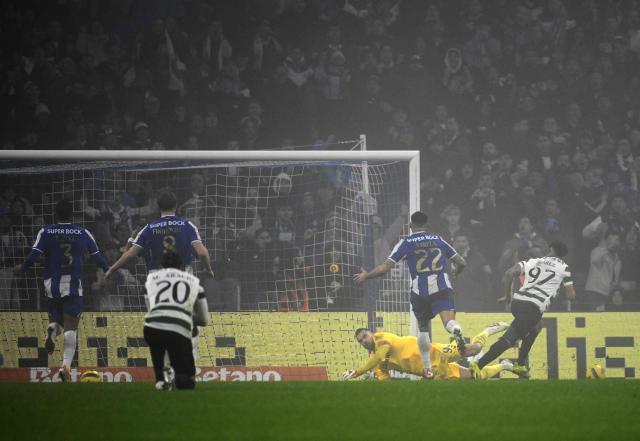 Sporting Lisbon's Colombian forward #97 Luis Suarez (R) scores his team's first goal in spite of FC Porto's Portuguese goalkeeper #99 Diogo Costa during the Portuguese League football match between FC Porto and Sporting CP at Dragao stadium in Porto, on February 9, 2026. (Photo by Miguel RIOPA / AFP)