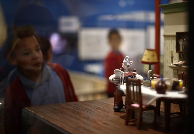 People look at the 'Dining room' set model, from Wallace & Gromit: Vengeance Most Fowl, 2024' during a photocall for the Inside Aardman: Wallace & Gromit and Friends exhibition at the Young V&A museum in London on February 9, 2026, to mark the 50th anniversary of British Oscar-winning animation studio Aardman. (Photo by Henry NICHOLLS / AFP)