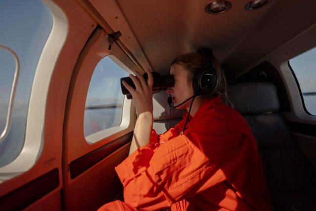 The Tactical Coordinator of the Humanitarian Pilot Initiative (HPI) scans the ocean with a pair of binoculars during a patrolling mission on January 22, 2025. The Swiss NGO, with 10 years of experience in central Mediterranean, is on its third mission on the Atlantic route, helping to spot distressed migrants boats and support rescues. Migrants leaving west Africa and traveling up the Atlantic are usually trying to reach Europe by first landing in the Canary Islands off northwestern Africa.
The Spanish archipelago is the jumping off point for their continued journey onward to the European continent.
More than 3,000 migrants died in 2025 while attempting to reach Spain clandestinely, according to the Spanish NGO Caminando Fronteras.
While HPI has operated for 10 years in the central Mediterranean, it is a relative newcomer to the Atlantic.
In the Mediterranean, it has already helped spot more than 1,000 boats, alerting international NGO rescue ships which can then go and help. (Photo by MICHELE CATTANI / AFP)