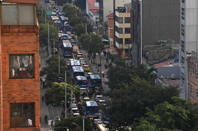 Vehicles drive along 13th Avenue during a traffic jam as they head toward downtown Bogota on February 9, 2026. (Photo by Diana SANCHEZ / AFP)