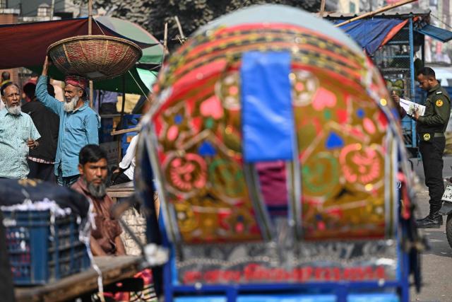 A man carries a basket across a marketplace ahead of Bangladesh's general election in Dhaka on February 10, 2026. (Photo by Sajjad HUSSAIN / AFP)