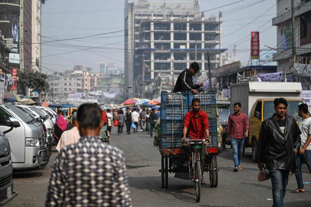A man transports carts of vegetables at a marketplace ahead of Bangladesh's general election in Dhaka on February 10, 2026. (Photo by Sajjad HUSSAIN / AFP)