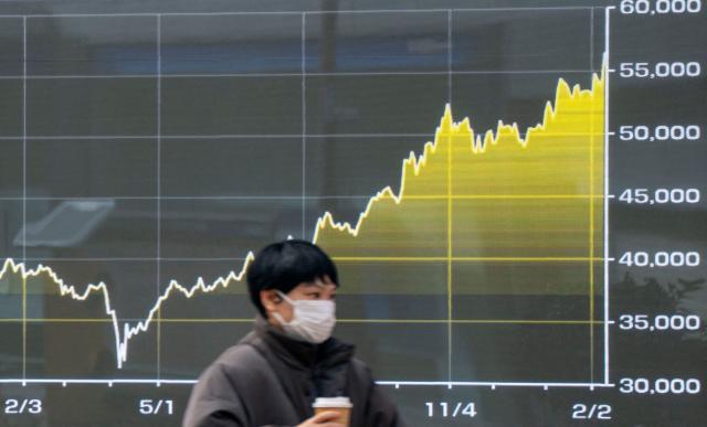 A graph showing the movement of average stock prices since last year is displayed on an electronic board along a street in Tokyo on February 10, 2026. (Photo by Kazuhiro NOGI / AFP)