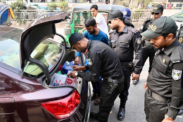 Bangladesh's Rapid Action Battalion personnel search a vehicle at a checkpoint in Dhaka on February 10, 2026 ahead of the country's general election on February 12. (Photo by MUNIR UZ ZAMAN / AFP)