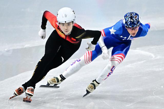 China's Zhang Chutong and US' Kristen Santos-Griswold compete in the short track speed skating women's 500m heats during the Milano Cortina 2026 Winter Olympic Games at Milano Ice Skating Arena in Milan on February 10, 2026. (Photo by JULIEN DE ROSA / AFP)