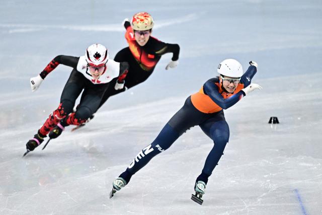 Netherlands' Selma Poutsma(R), Canada's Florence Brunelle (L) and China's Fan Kexin compete in the short track speed skating women's 500m heats during the Milano Cortina 2026 Winter Olympic Games at Milano Ice Skating Arena in Milan on February 10, 2026. (Photo by JULIEN DE ROSA / AFP)