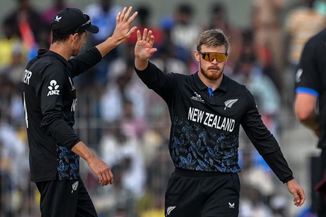 New Zealand's Glenn Phillips (R) celebrates with captain Mitchell Santner after taking the wicket of UAE's Harshit Kaushik during the 2026 ICC Men's T20 Cricket World Cup group stage match between New Zealand and United Arab Emirates at the MA Chidambaram Stadium in Chennai on February 10, 2026. (Photo by R. Satish BABU / AFP)