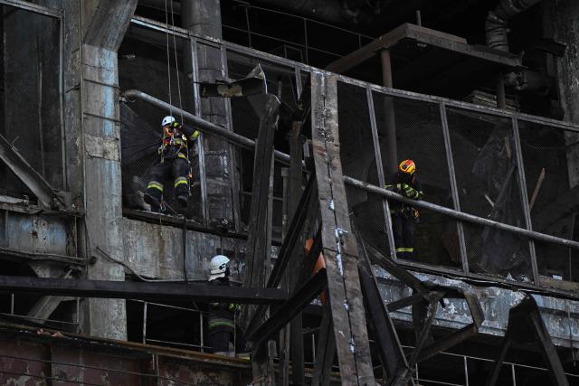 Rescuers of the State Emergency Service and employees of a power plant clear debris at a heavily damaged thermal power plant of the Ukrainian energy provider DTEK in an undisclosed location in Ukraine on February 9, 2026, following Russian missile and drone strikes amid the Russian invasion of Ukraine. (Photo by Genya SAVILOV / AFP)