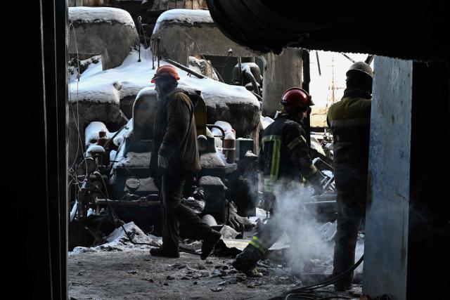 Rescuers of the State Emergency Service and employees of a power plant clear debris at a heavily damaged thermal power plant of the Ukrainian energy provider DTEK in an undisclosed location in Ukraine on February 9, 2026, following Russian missile and drone strikes amid the Russian invasion of Ukraine. (Photo by Genya SAVILOV / AFP)