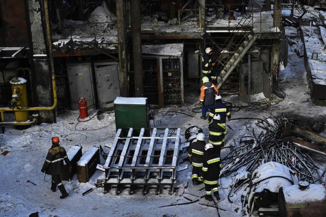 Rescuers of the State Emergency Service and employees of a power plant clear debris at a heavily damaged thermal power plant of the Ukrainian energy provider DTEK in an undisclosed location in Ukraine on February 9, 2026, following Russian missile and drone strikes amid the Russian invasion of Ukraine. (Photo by Genya SAVILOV / AFP)