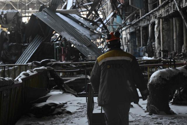An employee walks past a damaged equipment at a heavily damaged thermal power plant of the Ukrainian energy provider DTEK in an undisclosed location in Ukraine on February 9, 2026, following Russian missile and drone strikes amid the Russian invasion of Ukraine. (Photo by Genya SAVILOV / AFP)