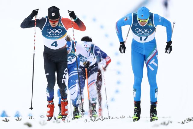Czech Republic's Jiri Tuz (L) and Italy's Simone Mocellini compete in heat 3 of the men's cross country sprint classic quarterfinal event of the Milano Cortina 2026 Winter Olympic Games at Tesero Cross-Country Skiing Stadium in Lago di Tesero (Val di Fiemme), on February 10, 2026. (Photo by Anne-Christine POUJOULAT / AFP)
