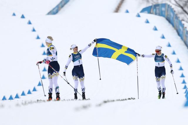 Gold medallist Sweden's Linn Svahn (R), bronze medallist Sweden's Maja Dahlqvist (C) and silver medallist Sweden's Jonna Sundling celebrate after competing during the women's cross country sprint classic final event of the Milano Cortina 2026 Winter Olympic Games at Tesero Cross-Country Skiing Stadium in Lago di Tesero (Val di Fiemme), on February 10, 2026. (Photo by Anne-Christine POUJOULAT / AFP)
