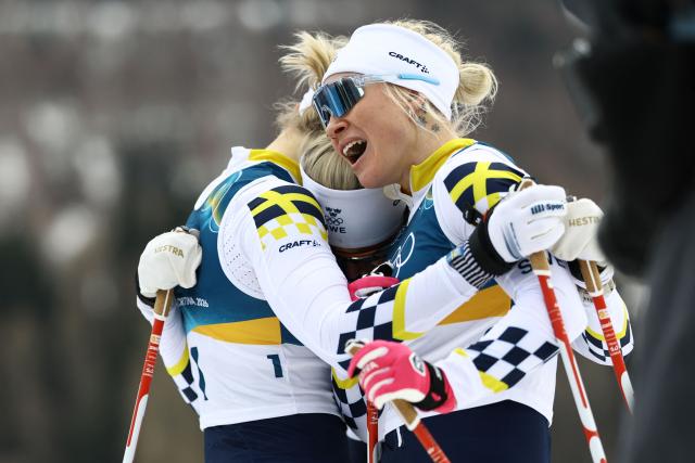 Gold medallist Sweden's Linn Svahn (L) celebrates with silver medallist Sweden's Jonna Sundling (R) and bronze medallist Sweden's Maja Dahlqvist after the women's cross country sprint classic final event of the Milano Cortina 2026 Winter Olympic Games at Tesero Cross-Country Skiing Stadium in Lago di Tesero (Val di Fiemme), on February 10, 2026. (Photo by Anne-Christine POUJOULAT / AFP)