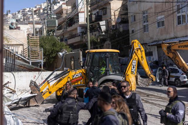 Israeli police move people away as heavy machinery demolishes a structure in the al-Bustan area of the Palestinian neighbourhood of Silwan, in Israeli-annexed east Jerusalem, on February 10, 2026. (Photo by ilia YEFIMOVICH / AFP)