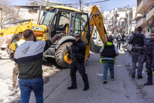 A resident (L) argues with a member of the Israeli police forces during the demolition of a structure in the al-Bustan area of the Palestinian neighbourhood of Silwan, in Israeli-annexed east Jerusalem, on February 10, 2026. (Photo by ilia YEFIMOVICH / AFP)
