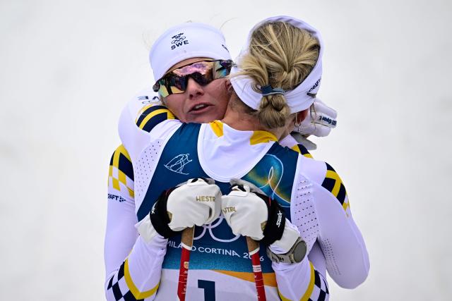Gold medallist Sweden's Linn Svahn (R) embraces bronze medallist Sweden's Maja Dahlqvist after competing during the women's cross country sprint classic final event of the Milano Cortina 2026 Winter Olympic Games at Tesero Cross-Country Skiing Stadium in Lago di Tesero (Val di Fiemme), on February 10, 2026. (Photo by Tobias SCHWARZ / AFP)