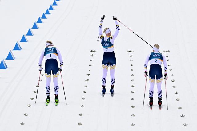 (From L) Gold medallist Sweden's Linn Svahn, bronze medallist Sweden's Maja Dahlqvist and Silver medallist Sweden's Jonna Sundling celebrate after competing during the women's cross country sprint classic final event of the Milano Cortina 2026 Winter Olympic Games at Tesero Cross-Country Skiing Stadium in Lago di Tesero (Val di Fiemme), on February 10, 2026. (Photo by Tobias SCHWARZ / AFP)