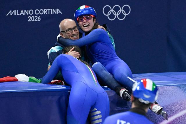 Team Italy's Elisa Confortola celebrates with team members after winning gold in the short track speed skating mixed team relay final during the Milano Cortina 2026 Winter Olympic Games at Milano Ice Skating Arena in Milan on February 10, 2026. (Photo by WANG Zhao / AFP)