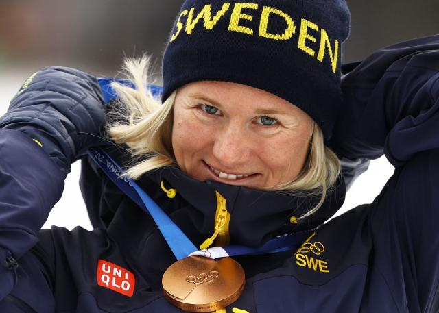 Bronze medallist Sweden's Maja Dahlqvist celebrates on the podium for the women's cross country sprint classic final event of the Milano Cortina 2026 Winter Olympic Games at Tesero Cross-Country Skiing Stadium in Lago di Tesero (Val di Fiemme), on February 10, 2026. (Photo by Anne-Christine POUJOULAT / AFP)