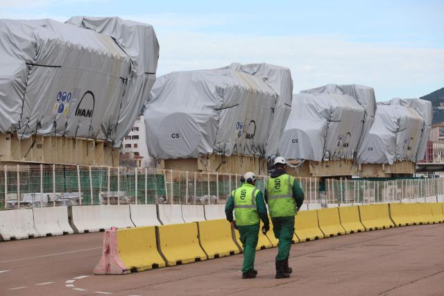 Workers walk by biofuel engines stored at the Ajaccio's port prior to their installation at the new Ajaccio's Ricanto electric central, in Ajaccio on the French Mediterranean island of Corsica on February 10, 2026. (Photo by Pascal POCHARD-CASABIANCA / AFP)