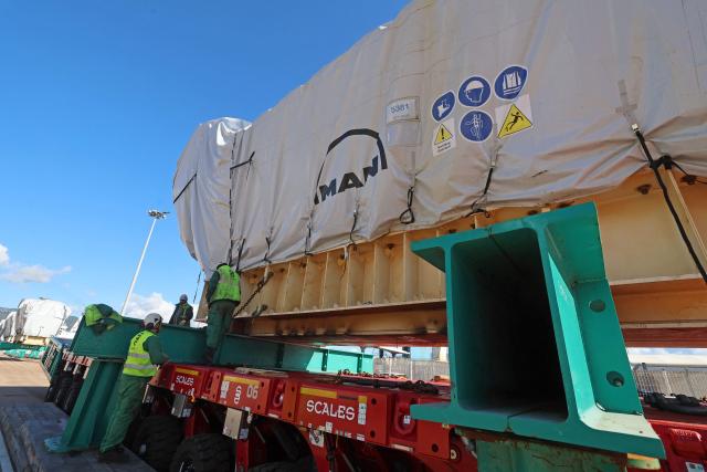 Workers unload a biofuel engine from a bunkering vessel at the Ajaccio's port prior to their installation at the new Ajaccio's Ricanto electric central, in Ajaccio on the French Mediterranean island of Corsica on February 10, 2026. (Photo by Pascal POCHARD-CASABIANCA / AFP)