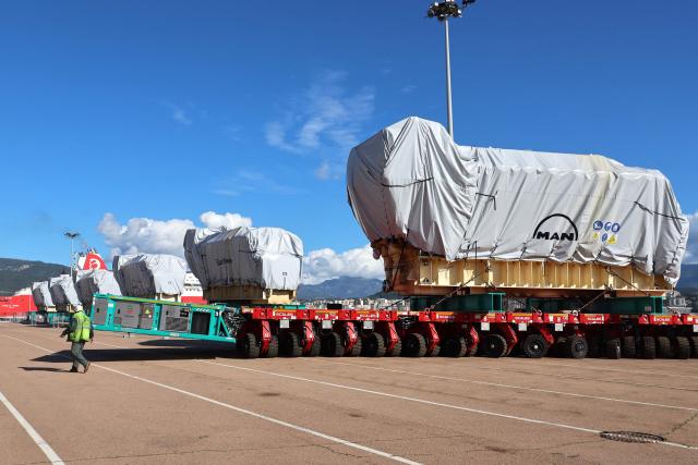 Workers unload a biofuel engine from a bunkering vessel at the Ajaccio's port prior to their installation at the new Ajaccio's Ricanto electric central, in Ajaccio on the French Mediterranean island of Corsica on February 10, 2026. (Photo by Pascal POCHARD-CASABIANCA / AFP)