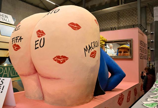 A carnival float featuring US President Donald Trump looking in the mirror and with traces of kisses on his bare backside is pictured during a presentation of this year's carnival floats of Cologne's carnival committee, on February 10, 2026 in Cologne. (Photo by INA FASSBENDER / AFP)