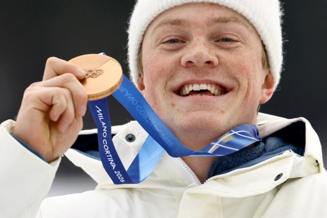 Bronze medallist Norway's Oskar Opstad Vike celebrates on the podium for the men's cross country sprint classic final event of the Milano Cortina 2026 Winter Olympic Games at Tesero Cross-Country Skiing Stadium in Lago di Tesero (Val di Fiemme), on February 10, 2026. (Photo by Anne-Christine POUJOULAT / AFP)