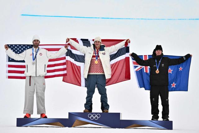 (From L) Silver medallist USA's Alex Hall, gold medallist Norway's Birk Ruud and bronze medallist New Zealand's Luca Harrington celebrate on the podium after the freestyle skiing men's freeski slopestyle final during the Milano Cortina 2026 Winter Olympic Games at Livigno Snow Park, in Livigno (Valtellina), on February 10, 2026. (Photo by Jeff PACHOUD / AFP)