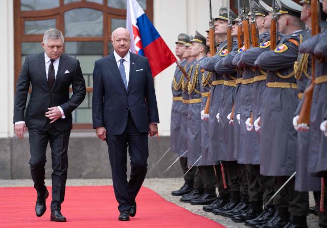 Slovakia's Prime Minister Robert Fico and Austria's Chancellor Christian Stocker review a military honor guard during a welcoming ceremony prior to the so-called S3 (Slavkov format) meeting with Czech Prime Minister in Bratislava, Slovakia, on February 10, 2026. (Photo by Joe Klamar / AFP)