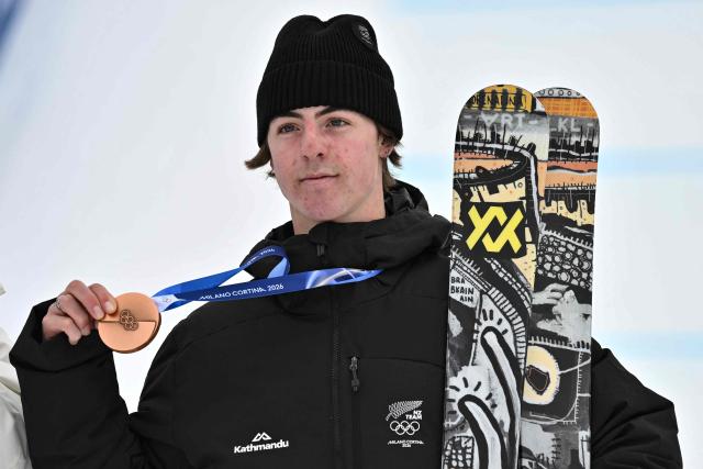 Bronze medallist New Zealand's Luca Harrington celebrates on the podium after the freestyle skiing men's freeski slopestyle final during the Milano Cortina 2026 Winter Olympic Games at Livigno Snow Park, in Livigno (Valtellina), on February 10, 2026. (Photo by Jeff PACHOUD / AFP)