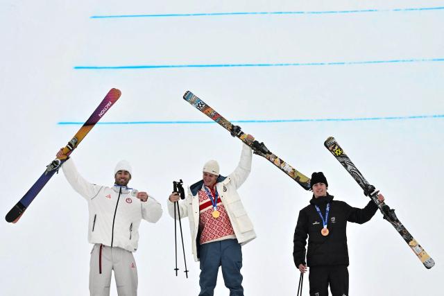 (From L) Silver medallist USA's Alex Hall, gold medallist Norway's Birk Ruud and bronze medallist New Zealand's Luca Harrington celebrate on the podium after the freestyle skiing men's freeski slopestyle final during the Milano Cortina 2026 Winter Olympic Games at Livigno Snow Park, in Livigno (Valtellina), on February 10, 2026. (Photo by Jeff PACHOUD / AFP)