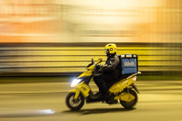 A foreign delivery worker rides a scooter in downtown Zagreb on February 3, 2026. As Croatia struggles with growing staff shortages, particularly in its key tourism sector, experts warn that it is leaving its badly needed foreign workers vulnerable to violence and exploitation. (Photo by MARKO PERKOV / AFP)