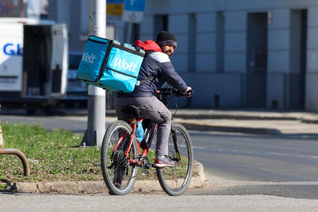 A foreign delivery worker rides a bicycle in downtown Zagreb on February 3, 2026. As Croatia struggles with growing staff shortages, particularly in its key tourism sector, experts warn that it is leaving its badly needed foreign workers vulnerable to violence and exploitation. (Photo by MARKO PERKOV / AFP)
