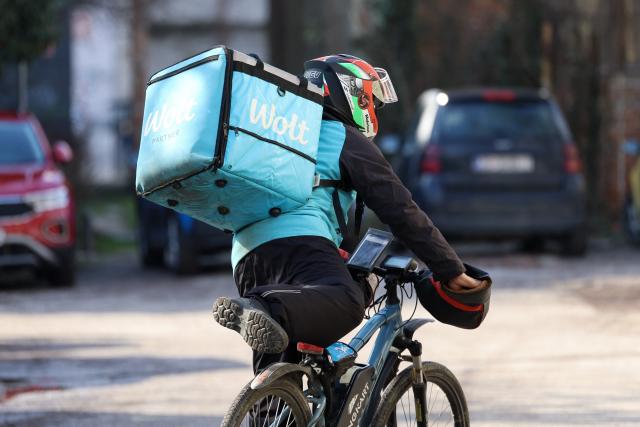 A foreign delivery worker rides a bicycle in downtown Zagreb on February 3, 2026. As Croatia struggles with growing staff shortages, particularly in its key tourism sector, experts warn that it is leaving its badly needed foreign workers vulnerable to violence and exploitation. (Photo by MARKO PERKOV / AFP)