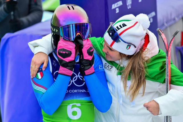 Italy's Martina Peterlini (L) reacts with teammate Italy's Laura Pirovano after skiing out in the slalom run of the women's team combined event during the Milano Cortina 2026 Winter Olympic Games at the Tofane Alpine Skiing Centre in Cortina d’Ampezzo on February 10, 2026. (Photo by Stefano RELLANDINI / AFP)