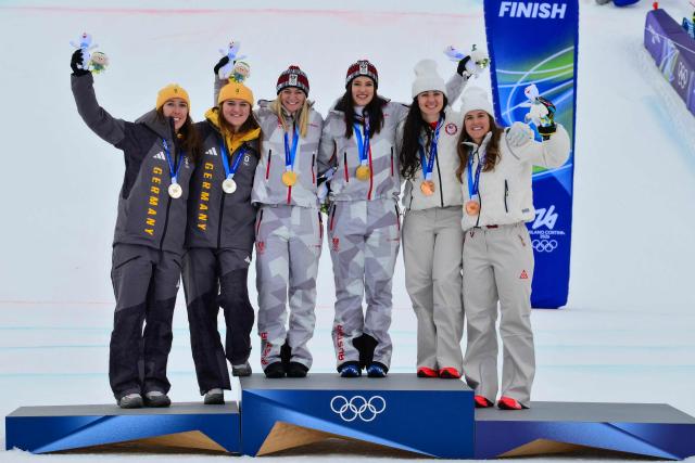 Gold medallists Austria's Ariane Raedler and Austria's Katharina Huber (C), silver medallists Germany's Kira Weidle-Winkelmann and Germany's Emma Aicher (L) and bronze medallists USA's Jacqueline Wiles and USA's A J Hurt (R) celebrate on the podium of the women's team combined event during the Milano Cortina 2026 Winter Olympic Games at the Tofane Alpine Skiing Centre in Cortina d’Ampezzo on February 10, 2026. (Photo by Stefano RELLANDINI / AFP)