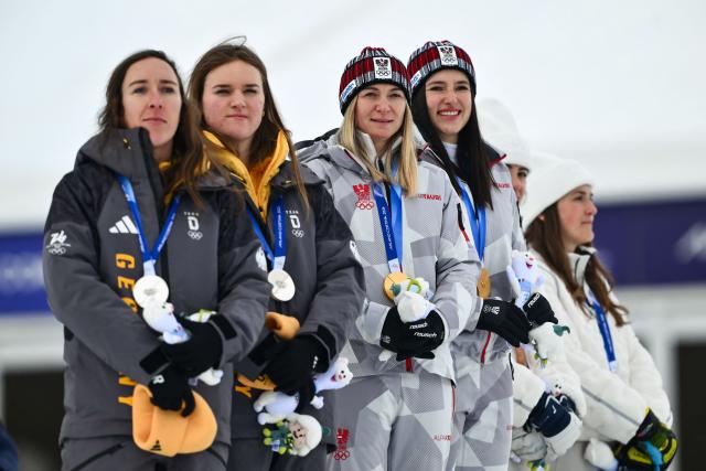 Gold medallists Austria's Ariane Raedler and Austria's Katharina Huber (C), silver medallists Germany's Kira Weidle-Winkelmann and Germany's Emma Aicher (L) and bronze medallists USA's Jacqueline Wiles and USA's A J Hurt (R) celebrate on the podium of the women's team combined event during the Milano Cortina 2026 Winter Olympic Games at the Tofane Alpine Skiing Centre in Cortina d’Ampezzo on February 10, 2026. (Photo by Marco BERTORELLO / AFP)